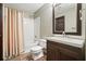 Bathroom with white tiled shower and dark wood vanity at 5770 Dorsett Shoals Rd, Douglasville, GA 30135