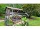Exterior elevation with a charming porch, American flag, garden, and lush landscaping at 5770 Dorsett Shoals Rd, Douglasville, GA 30135