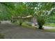 Exterior view of a home with a two-car garage and mature trees in a lush landscape at 5770 Dorsett Shoals Rd, Douglasville, GA 30135