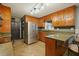 Well-lit kitchen featuring wood cabinetry and stainless steel refrigerator at 5770 Dorsett Shoals Rd, Douglasville, GA 30135