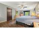 Well-lit main bedroom features wood floors, a ceiling fan, and neutral wall colors at 5770 Dorsett Shoals Rd, Douglasville, GA 30135