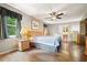 Comfortable main bedroom showcasing wood floors, a ceiling fan, and a large window at 5770 Dorsett Shoals Rd, Douglasville, GA 30135