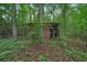 Dilapidated backyard storage shed surrounded by lush greenery at 5770 Dorsett Shoals Rd, Douglasville, GA 30135
