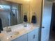 A bright bathroom featuring a dual sink vanity and a glass shower at 209 Ellis Ln, Woodstock, GA 30189