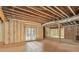 Spacious unfinished basement with exposed wood beams, insulation and a set of french doors at 7519 Waterview Cv, Douglasville, GA 30135