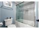 Modern bathroom features a tub with a glass shower door, a toilet, and minimalist décor at 7519 Waterview Cv, Douglasville, GA 30135