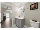 Well-lit bathroom featuring a vanity with a sink, a toilet, and doorway to an adjacent room at 7519 Waterview Cv, Douglasville, GA 30135