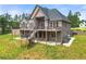 Brick home featuring a large deck, stairs leading to the backyard, and lush greenery at 7519 Waterview Cv, Douglasville, GA 30135