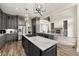 Open kitchen with gray cabinets, a marble island, stainless appliances, and access to the living area at 7519 Waterview Cv, Douglasville, GA 30135
