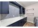 Well-organized laundry room with navy cabinets, patterned tile backsplash, and ample counter space at 7519 Waterview Cv, Douglasville, GA 30135