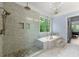 Spacious main bathroom with a glass-enclosed shower, soaking tub, and elegant chandelier at 7519 Waterview Cv, Douglasville, GA 30135