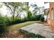 View of the backyard, showing the grass and patio with trees in the background at 6332 N Hampton N Dr, Atlanta, GA 30328