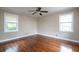 This bedroom features hardwood flooring, a ceiling fan, and natural light at 6332 N Hampton N Dr, Atlanta, GA 30328