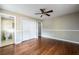 Well-lit bedroom with hardwood floors and wainscoting, offering views to the en-suite bathroom at 6332 N Hampton N Dr, Atlanta, GA 30328