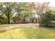 Brick ranch-style home on a grassy lot with trees and long driveway at 6332 N Hampton N Dr, Atlanta, GA 30328