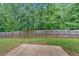 A grassy backyard is surrounded by a tall wooden fence and lush trees, offering privacy at 6350 Summer Pl, Douglasville, GA 30135