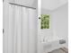 Bright bathroom with white vanity, a jacuzzi tub and a framed window at 6350 Summer Pl, Douglasville, GA 30135