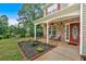 Charming covered porch with stone accents, decorative plantings, and cozy seating arrangement at 6350 Summer Pl, Douglasville, GA 30135