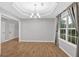 Formal dining room with decorative tray ceiling, wood floors, and a window with natural light at 6350 Summer Pl, Douglasville, GA 30135