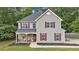 Charming two-story home featuring red shutters, a covered porch, and professionally landscaped front yard at 6350 Summer Pl, Douglasville, GA 30135