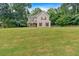Traditional home set on a sprawling green lawn surrounded by mature trees and well manicured landscaping at 6350 Summer Pl, Douglasville, GA 30135