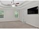 Spacious main bedroom with a tray ceiling, ceiling fan, neutral paint, and large windows at 6350 Summer Pl, Douglasville, GA 30135