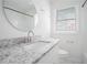 Well-lit bathroom featuring a stylish granite vanity and a large, round mirror at 1212 Eastridge Sw Rd, Atlanta, GA 30311