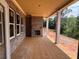 Covered patio featuring brick siding, a cozy fireplace, and elegant columns overlooking a green space at 2753 S Waterworks Rd, Buford, GA 30518