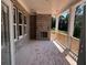 A covered porch features an brick fireplace, wood flooring, and an open view of the outdoors at 2753 S Waterworks Rd, Buford, GA 30518