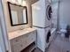 Bathroom featuring a modern sink, a stackable washer and dryer, and a full bathtub at 3011 Flat Shoals Sw Rd, Conyers, GA 30094