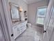 Bathroom featuring marble floors, a white vanity with marble countertop, and a decorative mirror at 3011 Flat Shoals Sw Rd, Conyers, GA 30094