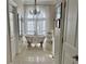 Elegant bathroom featuring a freestanding tub, chandelier, and large window with sheer curtains at 3011 Flat Shoals Sw Rd, Conyers, GA 30094