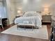 Bright bedroom with a large bed, neutral colored walls, wood floors, and a decorative rug at 3011 Flat Shoals Sw Rd, Conyers, GA 30094
