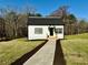 Charming home with a walkway and front porch surrounded by beautiful landscaping at 3011 Flat Shoals Sw Rd, Conyers, GA 30094