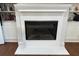 Close-up of a white fireplace with a black insert and built-in shelving on either side at 3011 Flat Shoals Sw Rd, Conyers, GA 30094