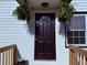 Close-up of a stylish front door with decorative plants and fresh exterior paint at 3011 Flat Shoals Sw Rd, Conyers, GA 30094
