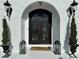Detailed view of the arched front door with ironwork, lanterns, and manicured greenery at 3011 Flat Shoals Sw Rd, Conyers, GA 30094