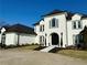 Elegant white home featuring a black roof, arched entrance, and well-manicured landscaping at 3011 Flat Shoals Sw Rd, Conyers, GA 30094