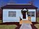 Charming home featuring new landscaping, and a cozy front porch adorned with hanging plants at 3011 Flat Shoals Sw Rd, Conyers, GA 30094