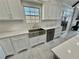 Bright kitchen with white cabinets, marble countertops, stainless steel appliances, and a farmhouse sink at 3011 Flat Shoals Sw Rd, Conyers, GA 30094