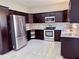 Modern kitchen featuring stainless steel appliances, dark cabinets, and granite countertops at 3011 Flat Shoals Sw Rd, Conyers, GA 30094