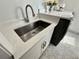 A stainless steel sink, modern faucet, white quartz countertop, and stylish tile flooring define the laundry room at 3011 Flat Shoals Sw Rd, Conyers, GA 30094