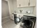 Laundry room featuring stainless steel washer and dryer, white cabinets, and modern quartz countertops at 3011 Flat Shoals Sw Rd, Conyers, GA 30094