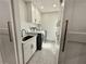 Small laundry room with patterned tile flooring, cabinets, sink and modern appliances at 3011 Flat Shoals Sw Rd, Conyers, GA 30094