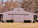 Large metal outbuilding featuring an awning and barn doors, framed by manicured bushes at 3011 Flat Shoals Sw Rd, Conyers, GA 30094