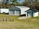 One of two garages in the yard is a shed with a roll-up door and white paint at 3011 Flat Shoals Sw Rd, Conyers, GA 30094