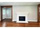 Cozy living room with a white painted fireplace and hardwood floors, perfect for relaxation and gatherings at 6538 N Sweetwater Rd, Lithia Springs, GA 30122