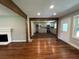 Open-concept living room showcases beautiful hardwood floors, brick fireplace, and natural wood beams at 6538 N Sweetwater Rd, Lithia Springs, GA 30122