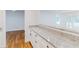 Bright kitchen featuring granite countertops, white cabinetry, and wood flooring at 1601 Augusta Se Dr, Marietta, GA 30067