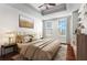 Luxurious main bedroom showcasing tray ceiling, a queen bed, and ample natural light from two windows at 325 E Paces Ferry Ne Rd # 703, Atlanta, GA 30305